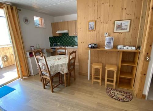 una cucina e una sala da pranzo con tavolo e sedie di T1 meublé 300 m plage - 20 m des commerces ad Argelès-sur-Mer