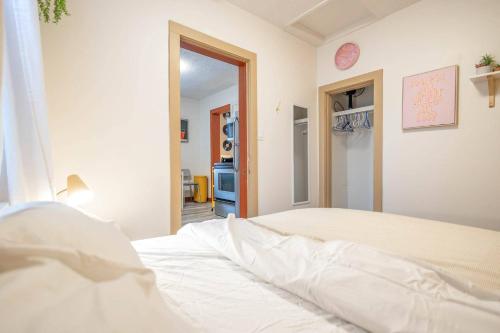 a bedroom with a white bed in a room at Retro Glam in Ramsay Walk to Stampede Grounds in Calgary