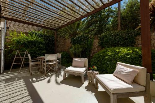 a patio with chairs and a table and a pergola at Galboka Residence in Nerezine