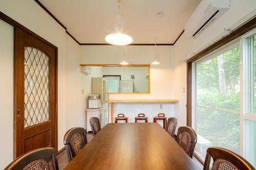a conference room with a wooden table and chairs at 富士見テラス山中湖マイペンライ in Yamanakako