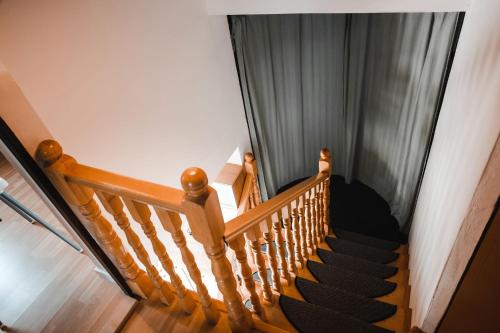 a stairway with a wooden rail and a window at Chata Achát in Turany nad Ondavou