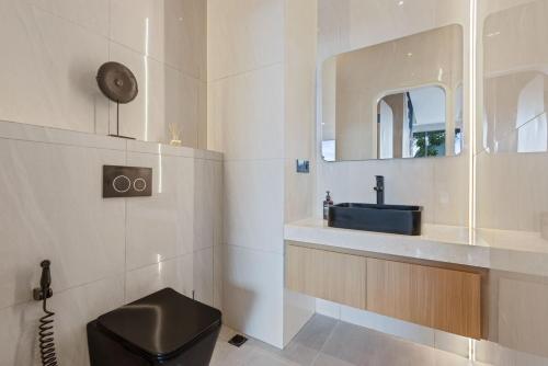 ケロボカンにあるNew 2BR Architectural Masterpiece in Umalasのバスルーム(黒いトイレ、シンク付)