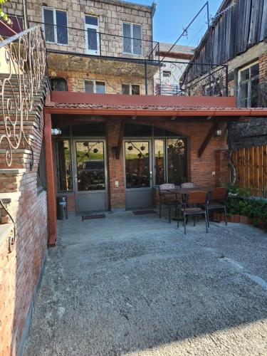 a brick building with a patio with a table and chairs at Old Gate Inn in Akhaltsikhe