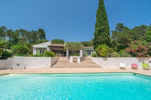a swimming pool in front of a house at Villa Hokiss Piscine privée dans parc 1 hectare in Le Muy