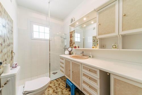 a white bathroom with a toilet and a sink at Villa Hokiss Piscine privée dans parc 1 hectare in Le Muy