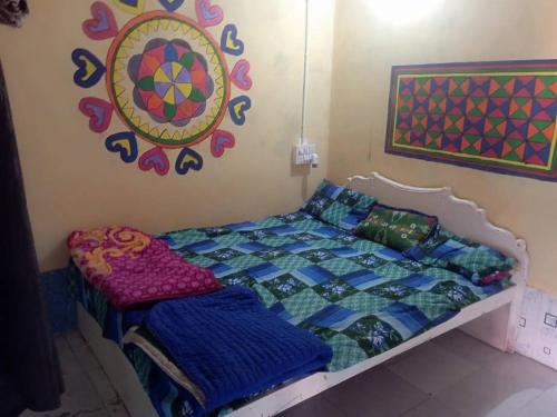 a bedroom with a bed and a painting on the wall at Ranfamily home stay in Dhordo