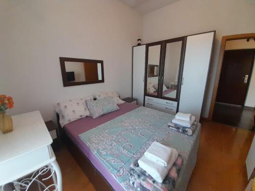 una piccola camera da letto con un letto e uno specchio di Apartment Nesrine a Bihać