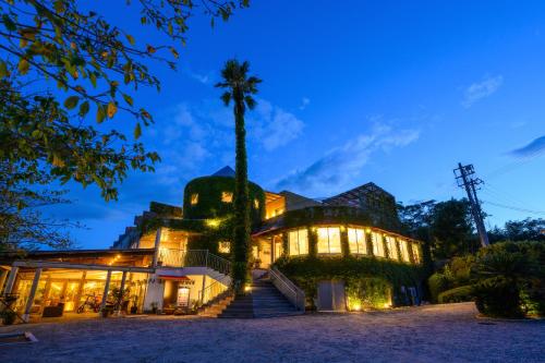 a building with a palm tree in front of it at Resort Hotel Moana Coast in Naruto