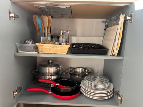 a pantry with dishes and utensils on a shelf at Maison avec jardin à l'île de la Réunion in Le Port