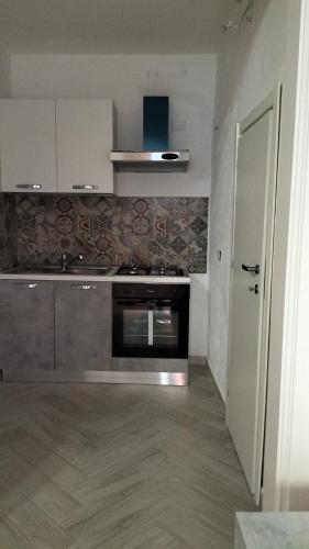 a kitchen with a stainless steel stove and a door at Casa vacanze Don Fefè in Ispica