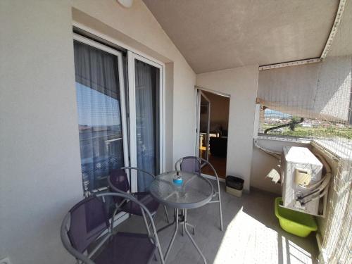 un tavolo e delle sedie in una stanza con una finestra di Apartment Nesrine a Bihać