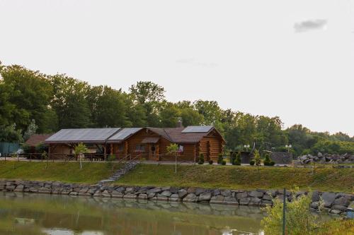 a log cabin next to a body of water at Ray Eco Resort in Mukacheve