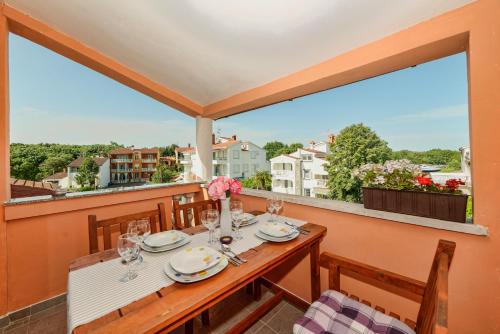 una mesa y sillas en un balcón con vistas en Holiday Home & Apartments Primavera, en Pula