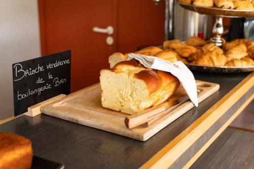 Una hogaza de pan sobre un mostrador en una panadería. en Hôtel La Petite Auberge, en Chambretaud