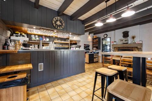 un bar dans un restaurant avec un comptoir et des tabourets dans l'établissement Hôtel La Petite Auberge, à Chambretaud