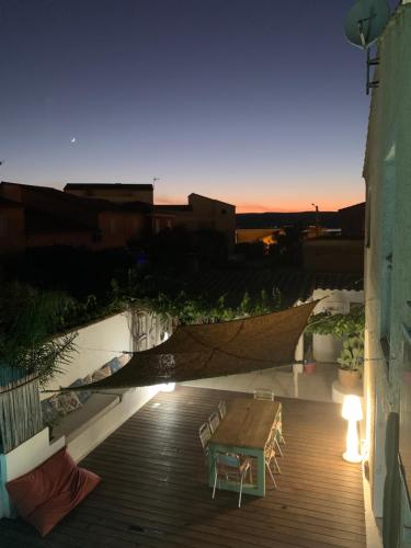 un patio avec une table et des chaises sur un bâtiment dans l'établissement Villa Les Dunes, à Frontignan