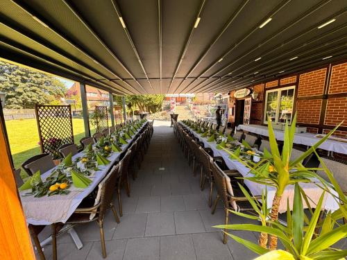 an outdoor patio with tables and chairs and plants at Hotel Zum Böhmegrund in Bad Fallingbostel