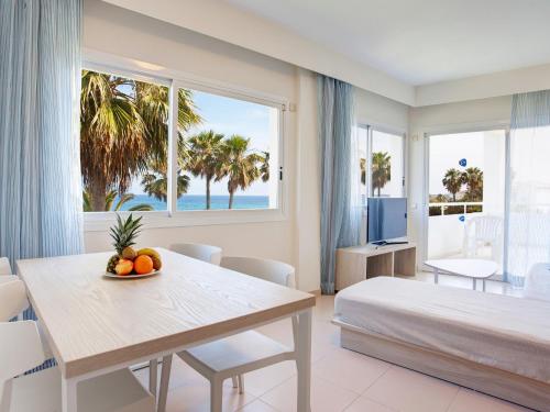 Un dormitorio con una cama y una mesa con fruta. en Grupotel Mallorca Mar, en Cala Bona