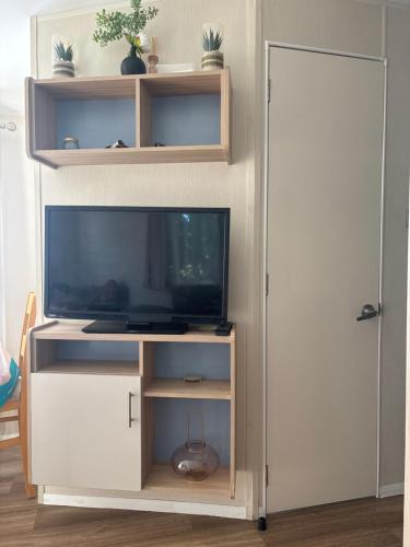 a entertainment center with a television and a door at Singh&Leite Family caravan for 10 people with 2toilets and lovely Decking in Jaywick Sands