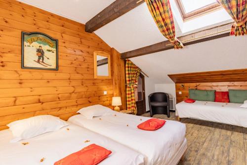 two beds in a room with wooden walls at Les Glières - Champagny-en-Vanoise in Champagny-en-Vanoise