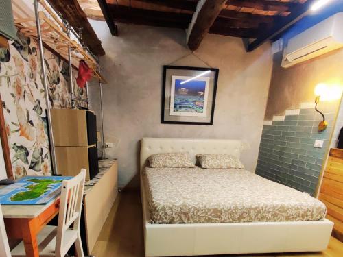 a small bedroom with a bed and a table at Casa della spiaggetta in Rio Marina