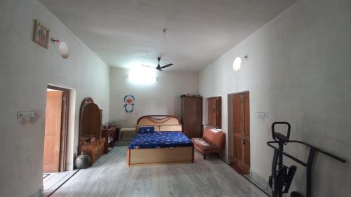 a bedroom with a bed in the corner of a room at Vashu's Sweet Home in Bikaner