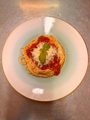 a plate of pasta with sauce and a garnishment at Grand Hotel in Soltau