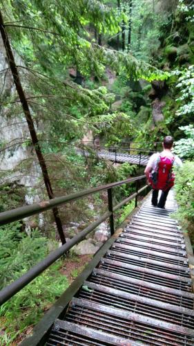 a person with a backpack walking on a bridge at Apartment Schlafwandler in Steinigtwolmsdorf