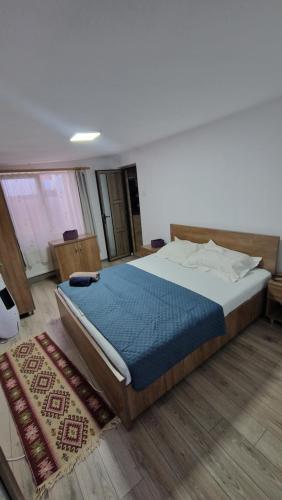 a bedroom with a large bed with a blue blanket at Casa AVA 2 Mai in 2 Mai