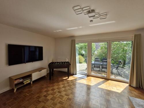 a living room with a flat screen tv on a wall at FeWo AllerGrün, Terrasse, Garten, Stellplatz! in Borstel