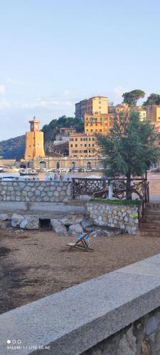 a stone wall with a tree in front of a city at Casa della spiaggetta in Rio Marina