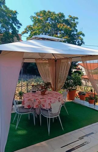 a tent with a table and chairs under it at Traditional house at Pelion seaside in Agria