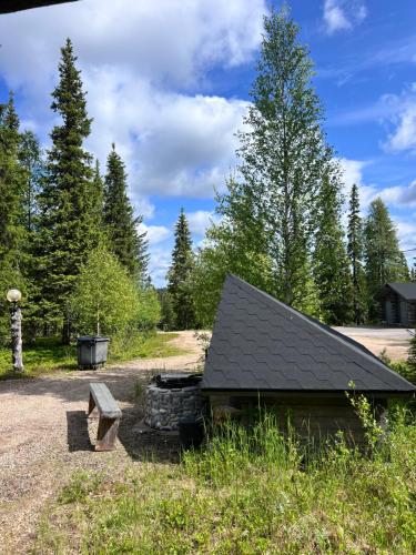 a log cabin with a fire pit in a field at Villa Karhunkehto in Luosto