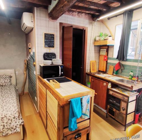 a small kitchen with a sink and a microwave at Casa della spiaggetta in Rio Marina