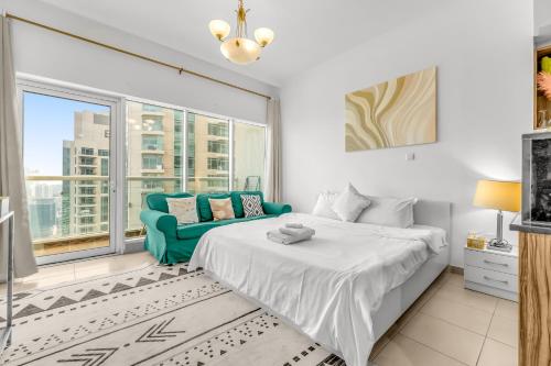a bedroom with a bed and a couch and a window at Burj Al Nujoom Luxurious Apartment Downtown Dubai Mall in Dubai