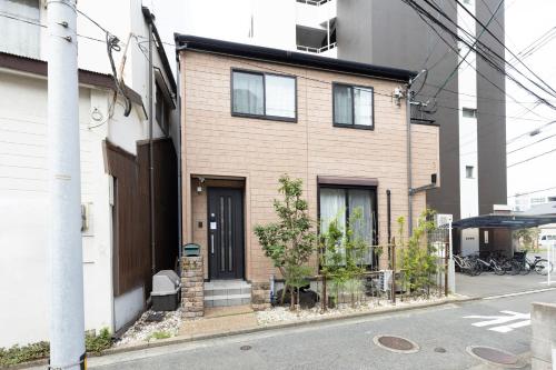a brown brick house on the side of a street at Chiyo House x M&Z HOUSE in Fukuoka