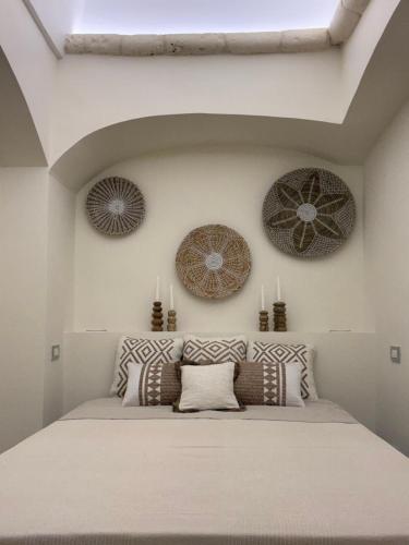 een slaapkamer met een bed met kussens erop bij PugliAlcove in Castellana Grotte