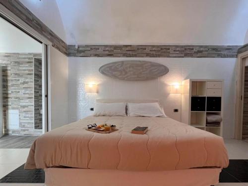a bedroom with a large bed with a tray on it at Dolce Vita Terrace On the Ocean - Veranda Sul Mare in Vieste