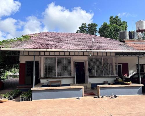 a house with a roof with a table in front of it at Farm Pathayapura in Nīleswaram