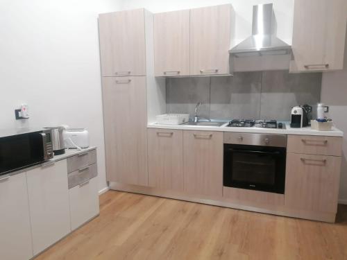 a kitchen with white cabinets and a stove top oven at Urban house in Favara