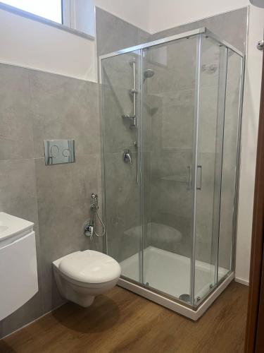 a bathroom with a glass shower with a toilet at Urban house in Favara