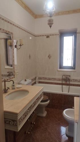 a bathroom with a sink and a toilet and a mirror at Suite Di Bella Taormina in Roccalumera