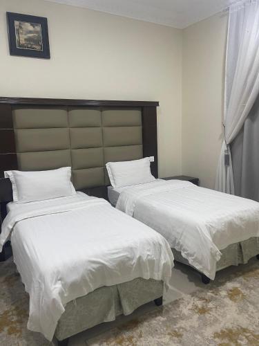 two beds sitting next to each other in a bedroom at بسمة الفخامة للشقق المخدومة in Abu Arish