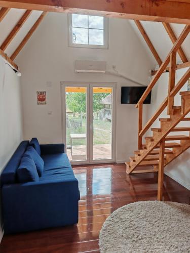 a living room with a blue couch and a staircase at Vila Dobrila, Tenis kućica in Avala