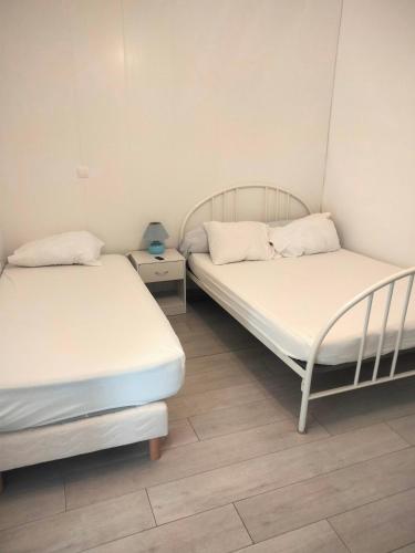 - une chambre avec 2 lits et une table de nuit dans l'établissement Appartement meublé neuf, près de Paris et Beauvais, à Amblainville