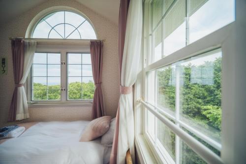 a bedroom with a bed and a large window at 伊豆集 Episode IZU in Ito