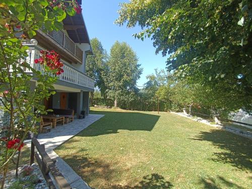 une cour attenante à une maison avec une grande pelouse dans l'établissement Tranquil Retreat - "Villa Green Oasis", à Sarajevo