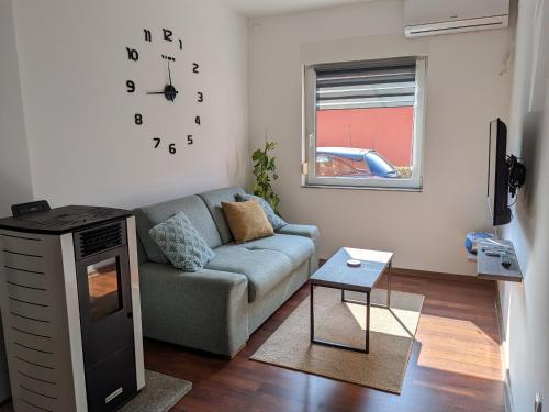 a living room with a couch and a clock on the wall at kuća za odmor Dolno in Sisak