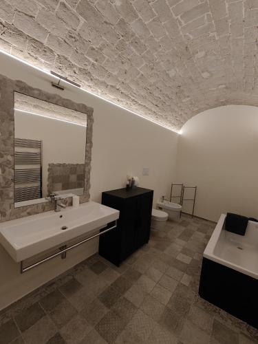 a bathroom with a sink and a mirror and a toilet at La casa del tempo in Vittorito