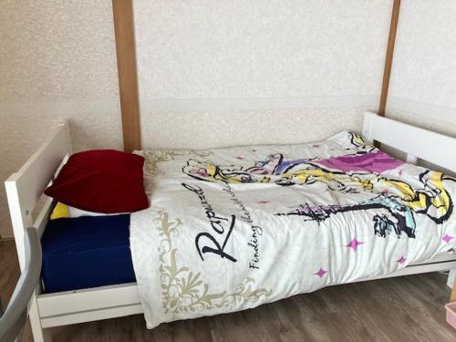 a small childs bed with a white frame at テラハウス国立 Terahouse Kunitachi in Kunitachi